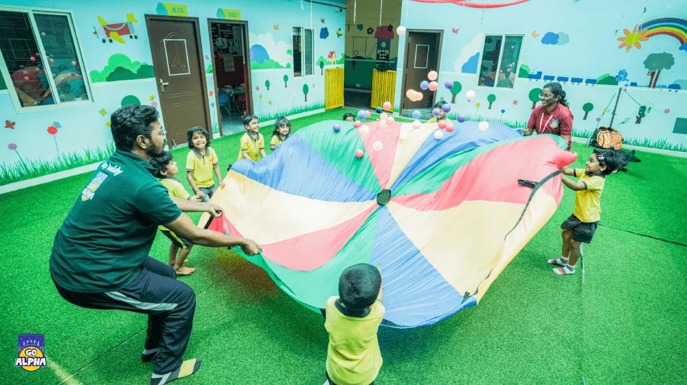 Go Alpha coaches in Pune lead preschoolers in a fun parachute game, a group activity that helps develop gross motor skills and teamwork.