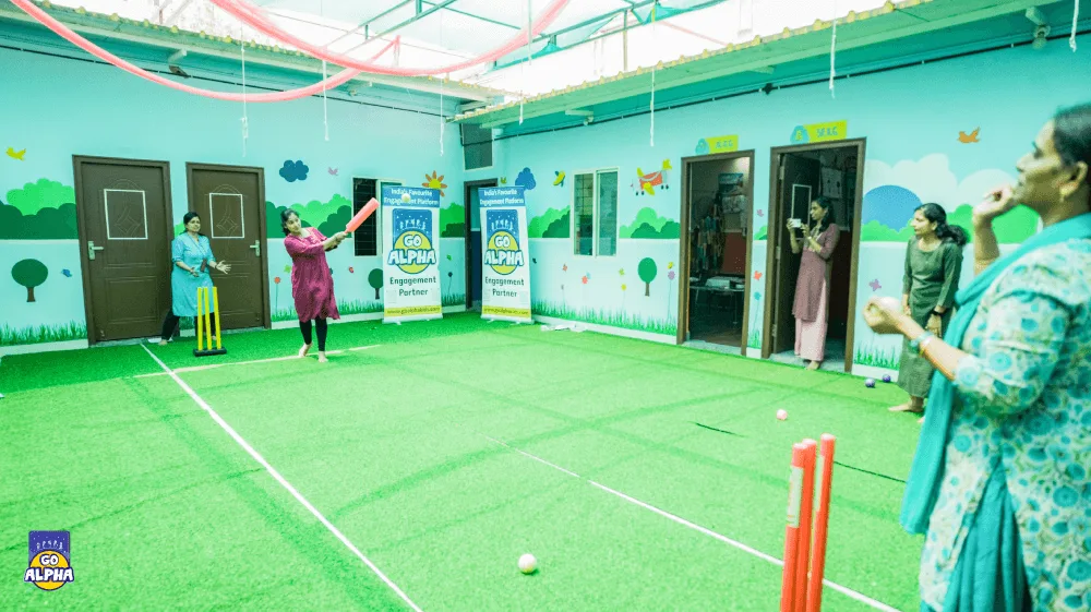 Adults participating in a cricket match during a corporate wellness event hosted by Go Alpha at their indoor sports facility in Pune.