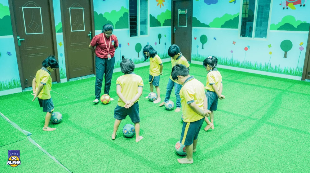 A Go Alpha coach in Pune instructs preschoolers on football fundamentals during a skill-building session, enhancing their coordination and focus.